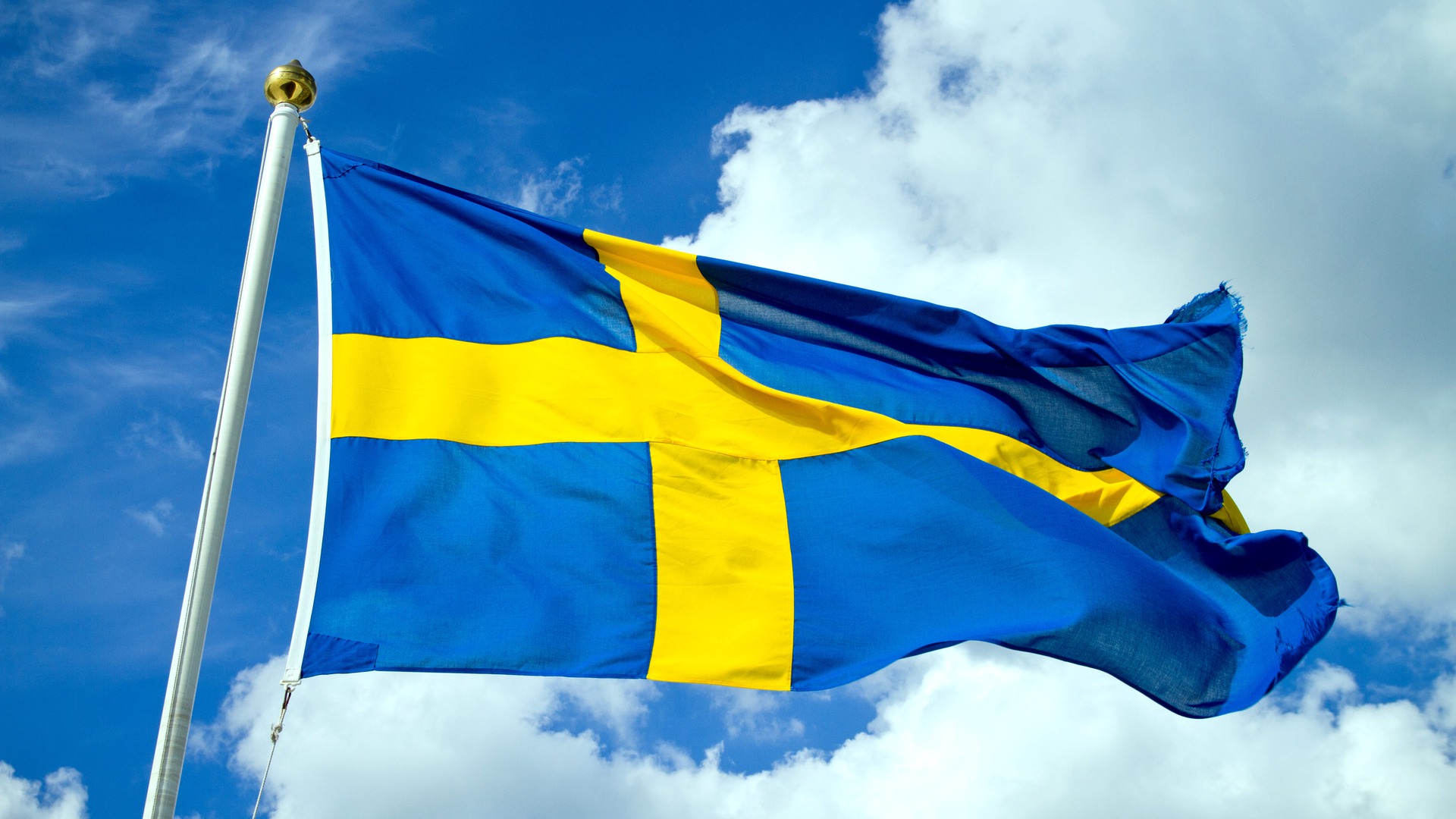 En svensk flagga vajar i vinden.