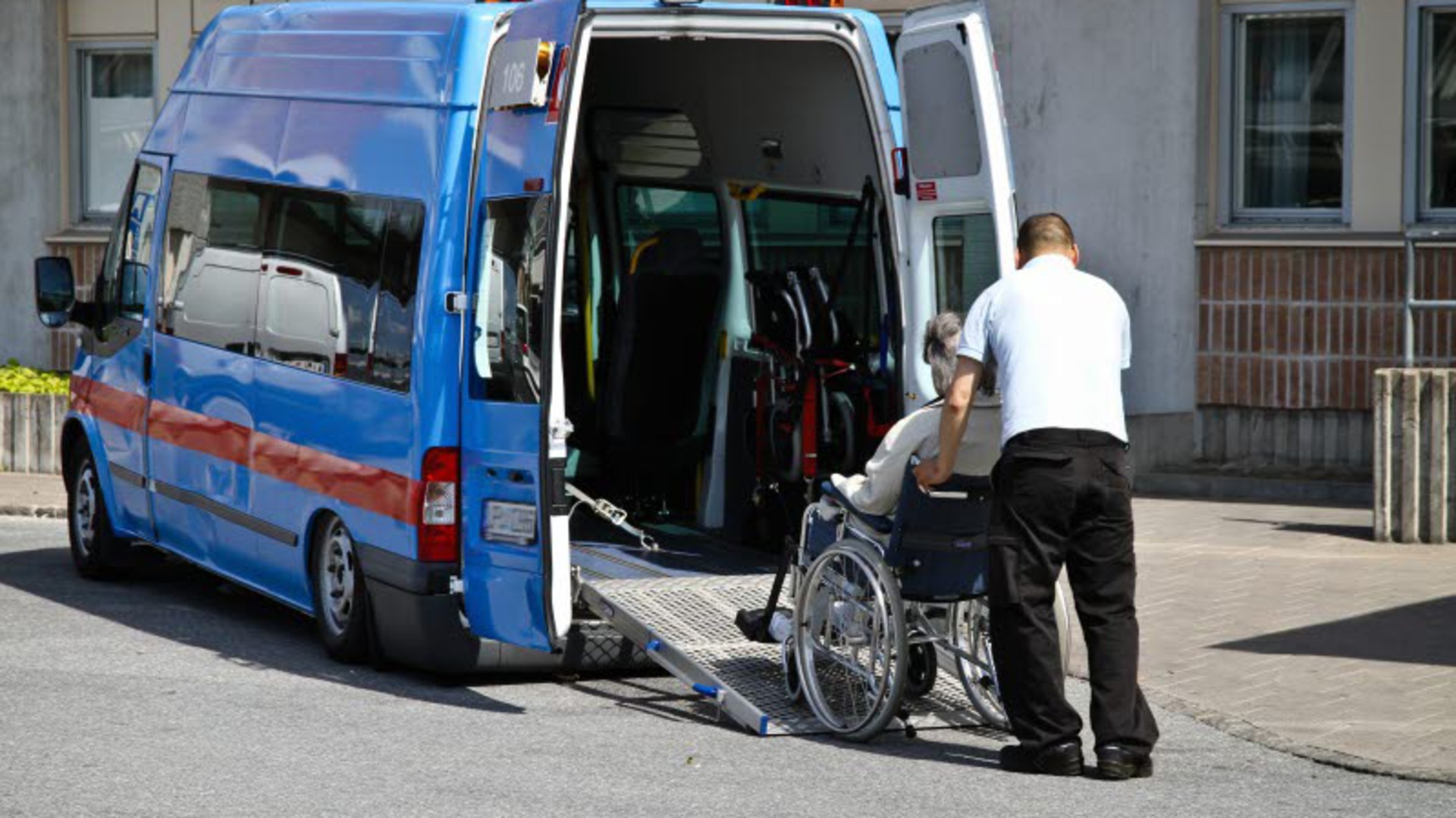 En person i rullstol rullas in i en färdtjänstbuss.