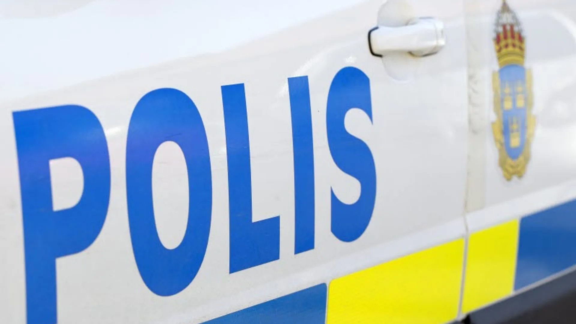Polisens logotyp på en polisbil.
