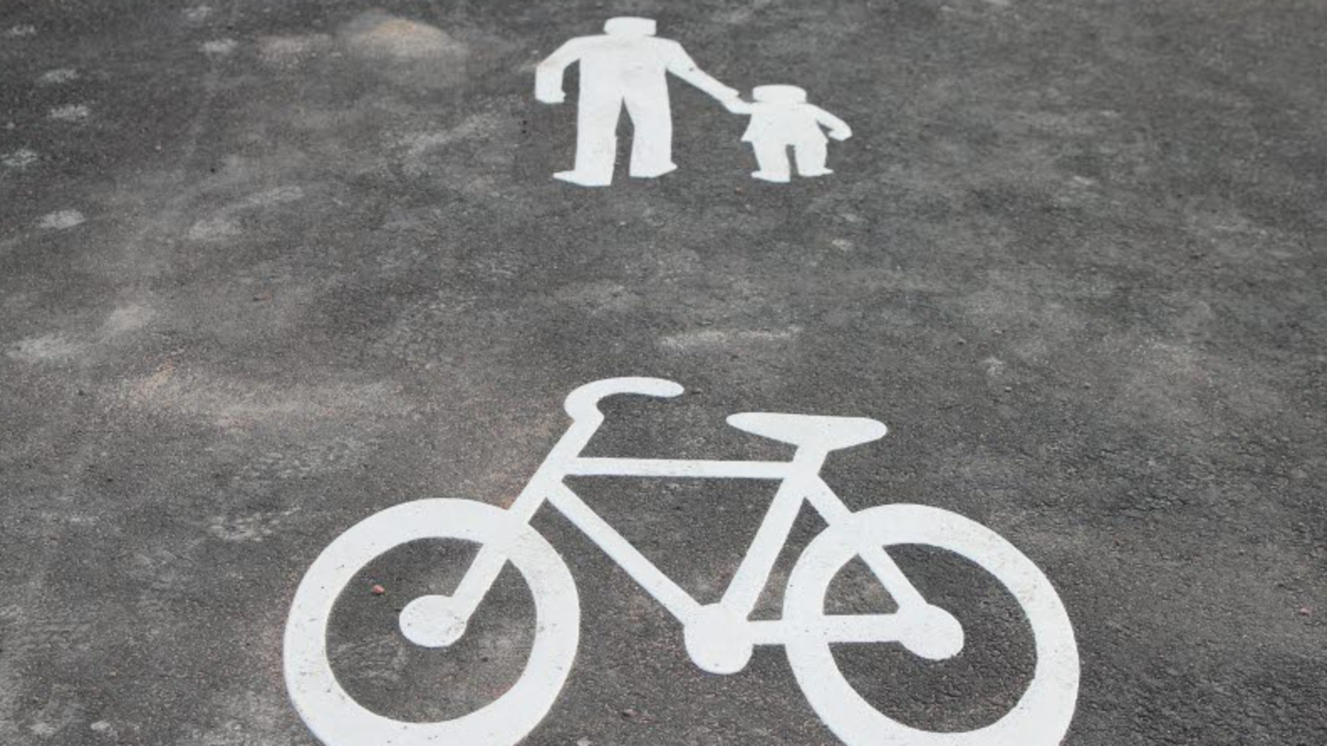 Asfalt med symbolerna för cykelväg och gångväg.