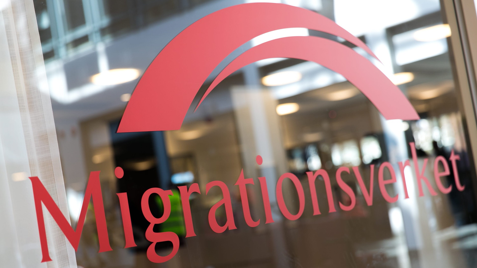 Migrationsverket logotyp på en fönsterruta. 