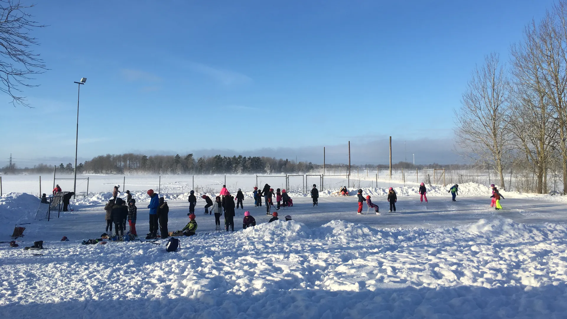 Barn åker skridskor på isbanan vid Korsberga skola.