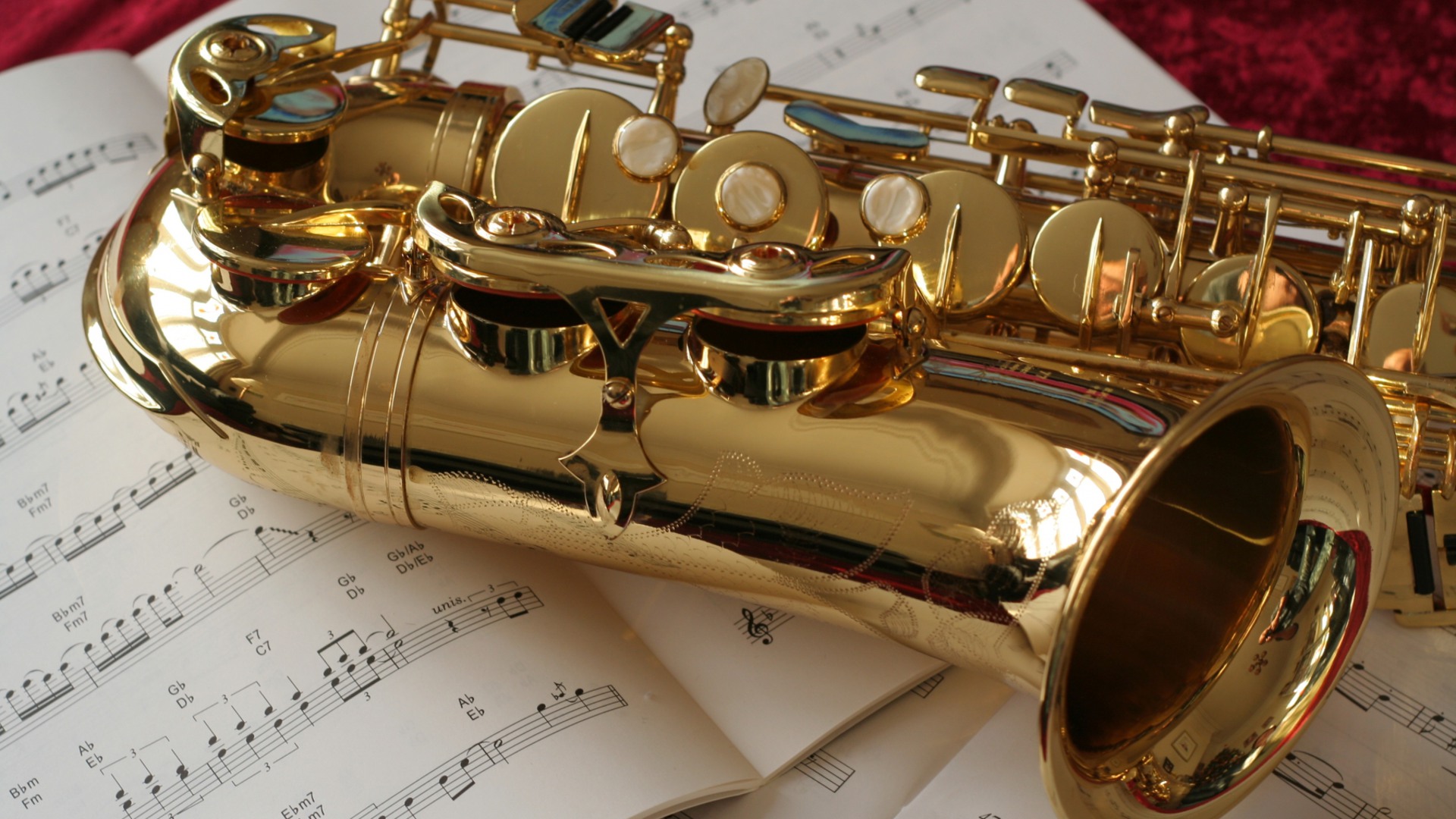 Närbild på saxofon som ligger på notpapper.