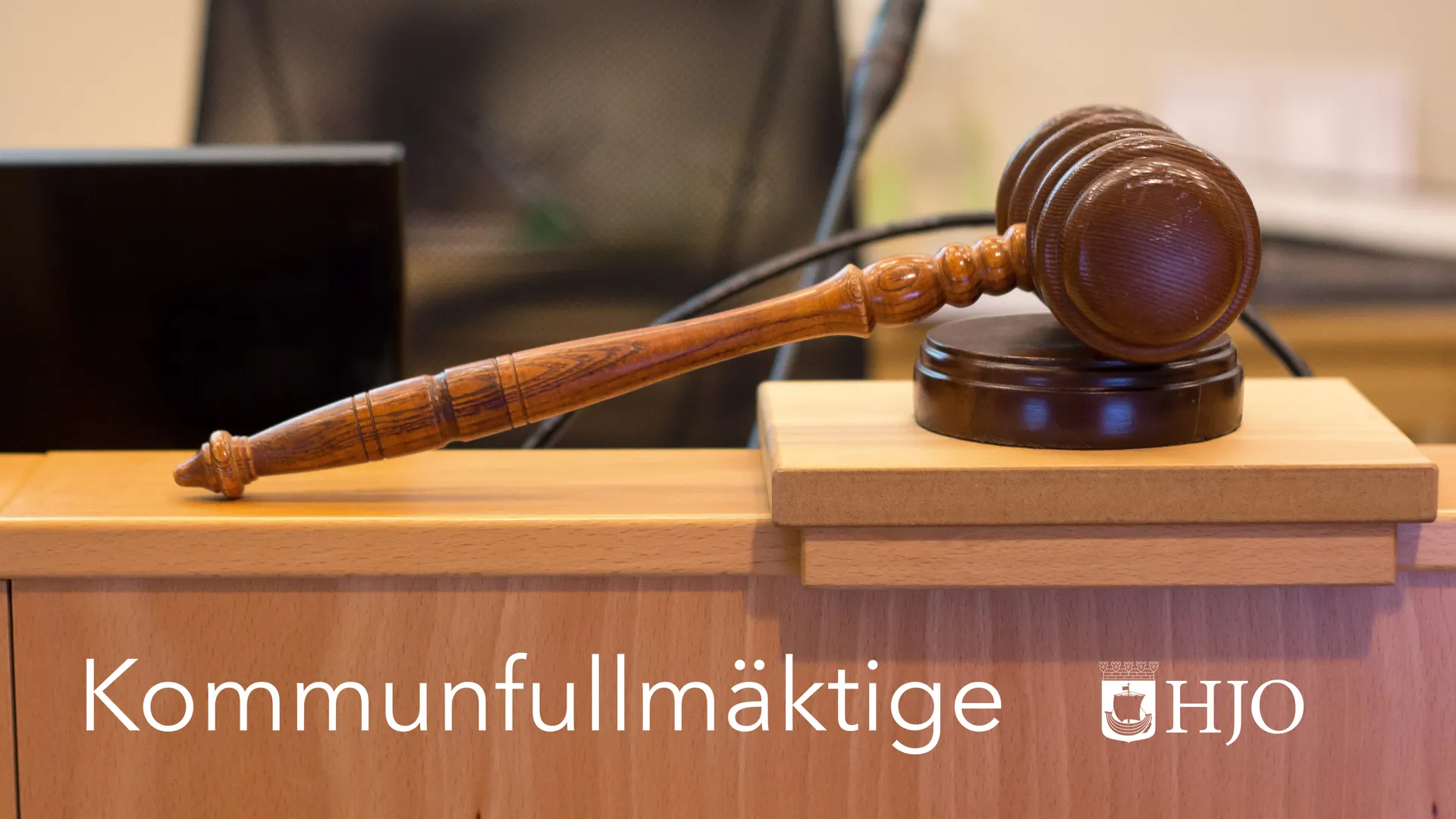 Beslutsklubba och texten "Kommunfullmäktige Hjo"
