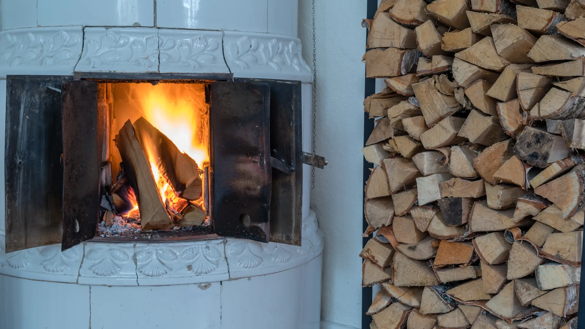 Värmande brasa i kakelugn