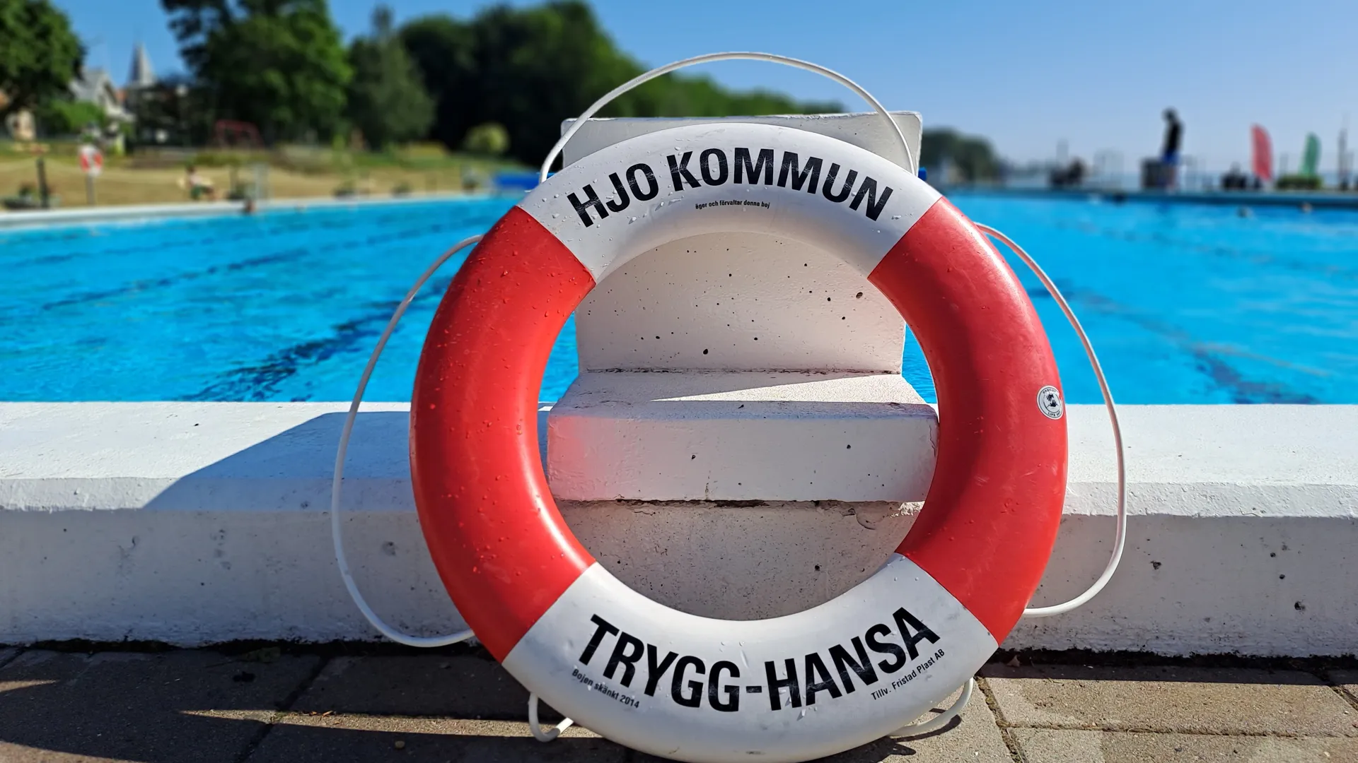 Livräddningsboj som står lutad mot startpall intill bassängen på Guldkroksbadet