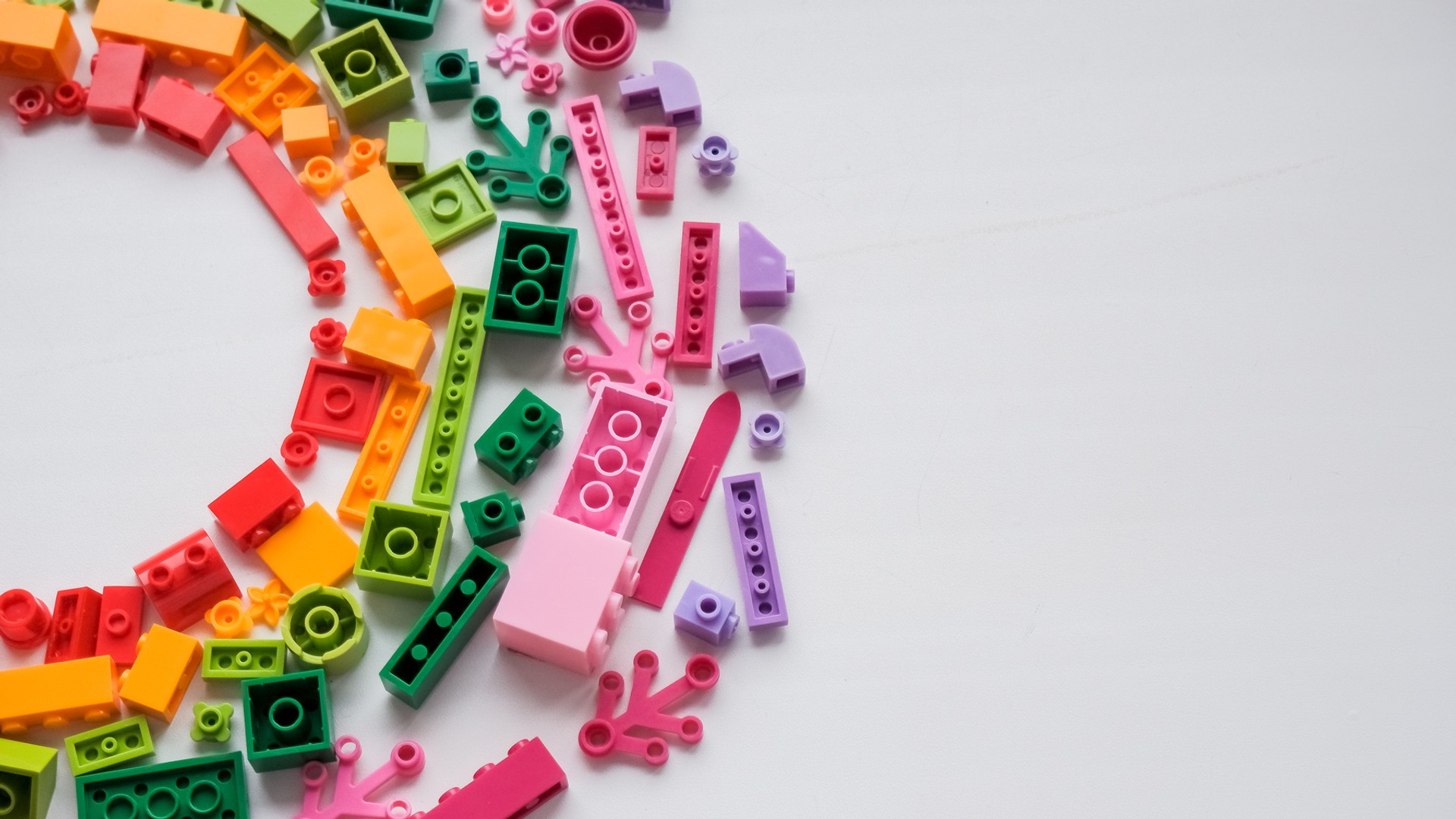 Legobitar i regnbågsfärger utlagda i en cirkel.