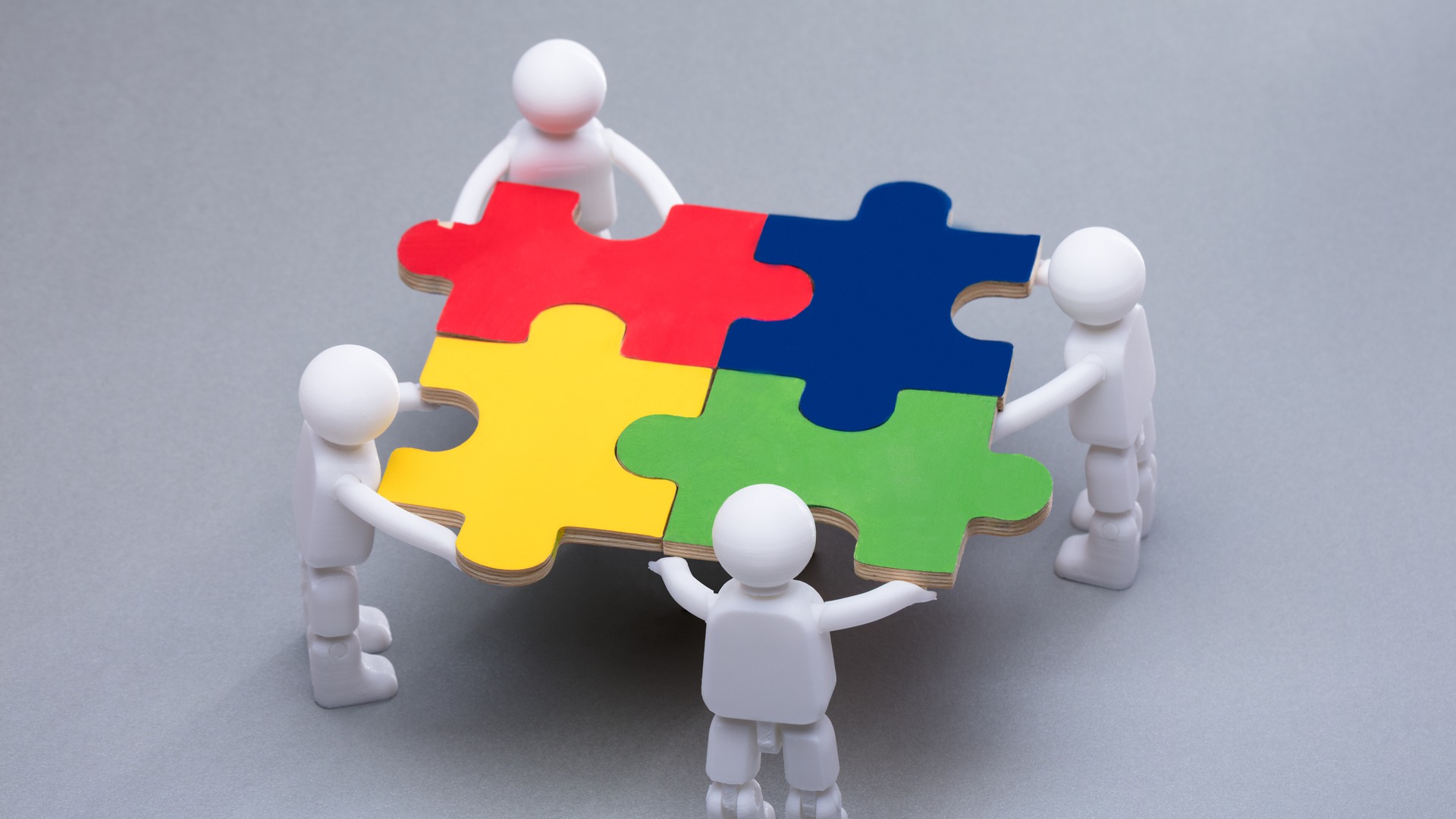 High Angle View Of Human Figures Solving Multi Colored Jigsaw Puzzles