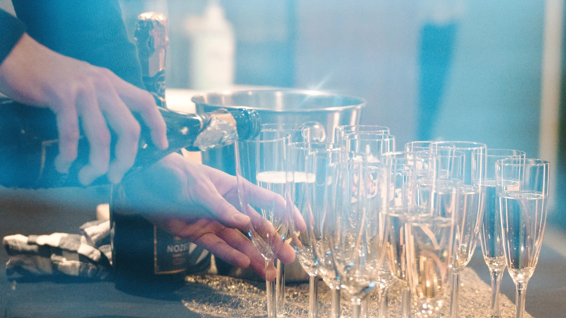 Någon häller upp dryck i champagneglas