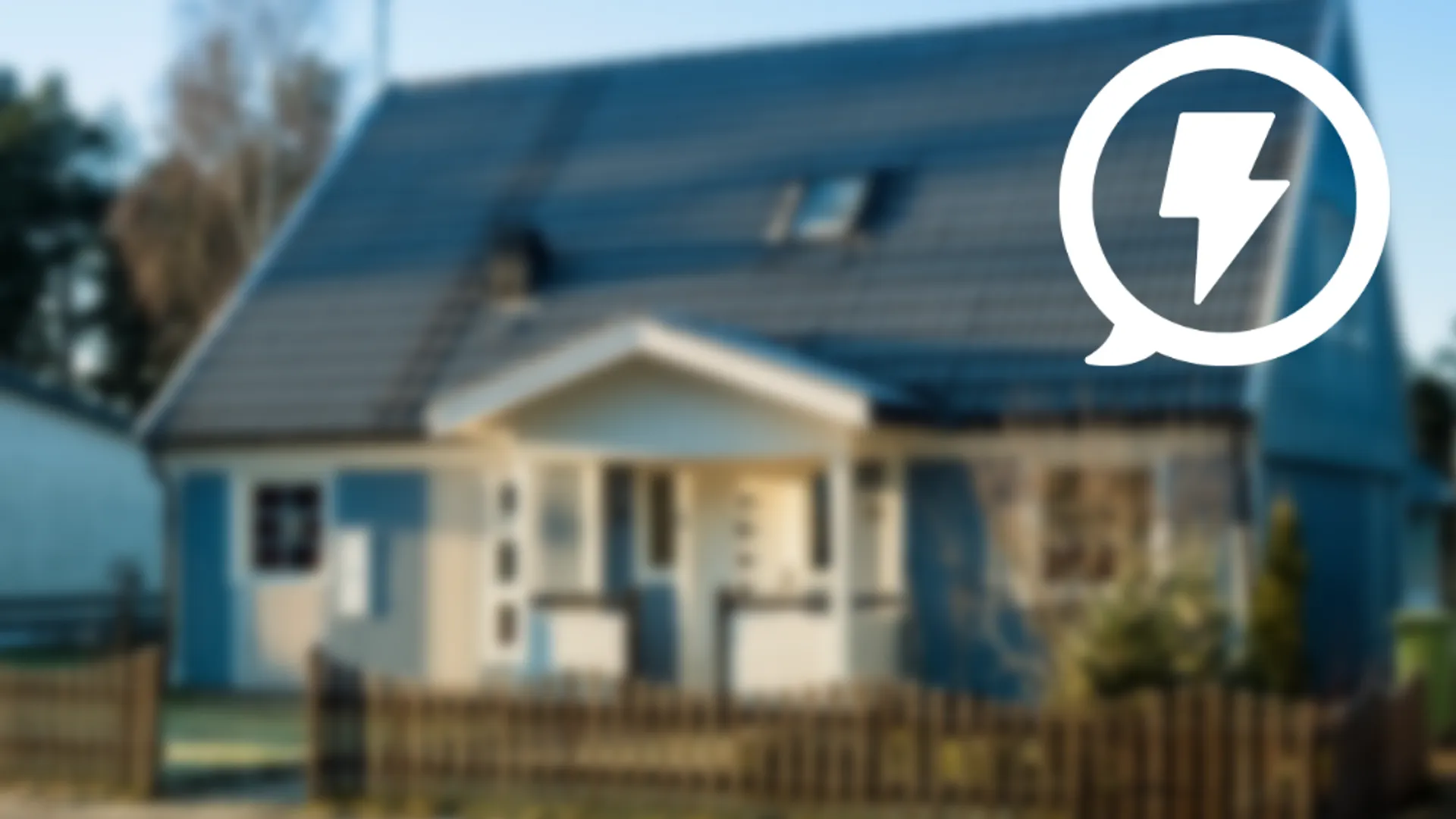 I bakgrunden finns en villa som är ur fokus. I fokus finns en energisymbol.