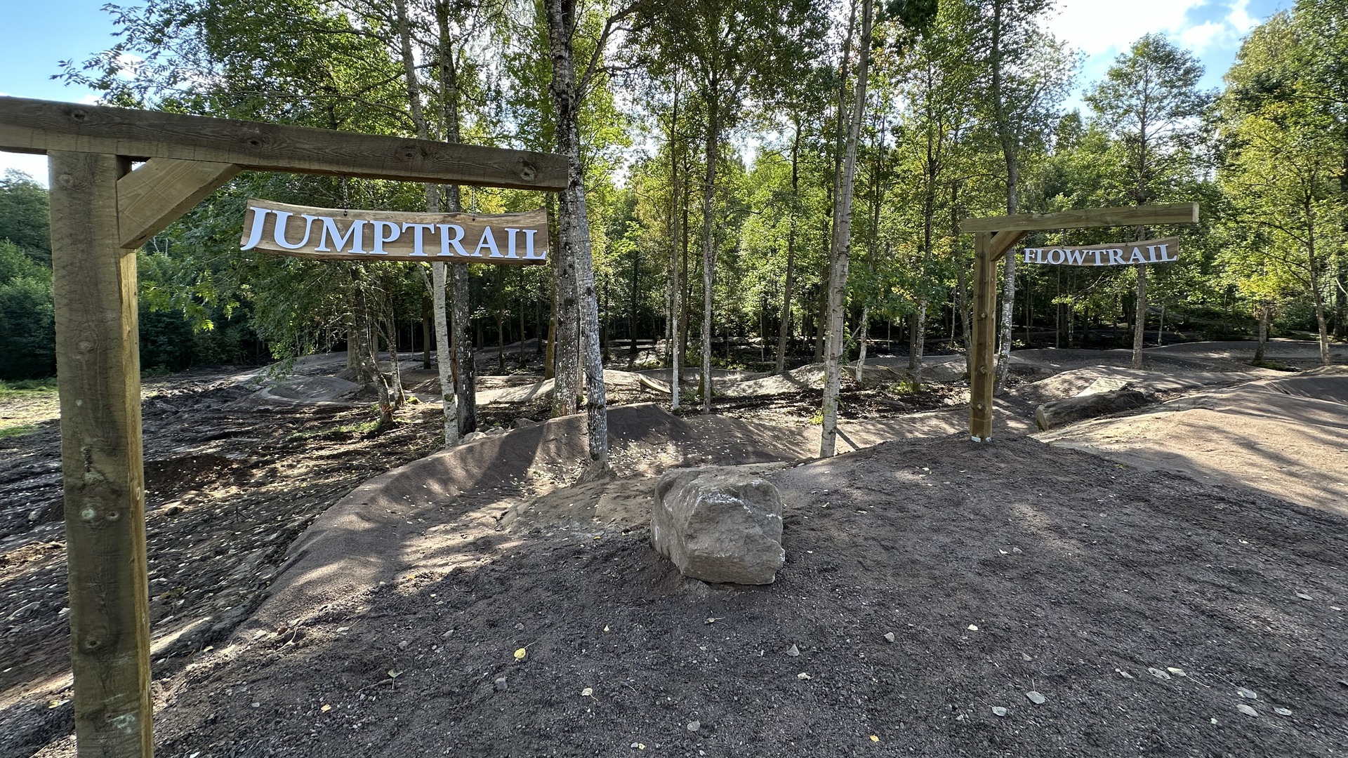 Delar av mountainbike-arenan på Högaliden. Skyltar med texten "jumptrail" och "flowtrail".