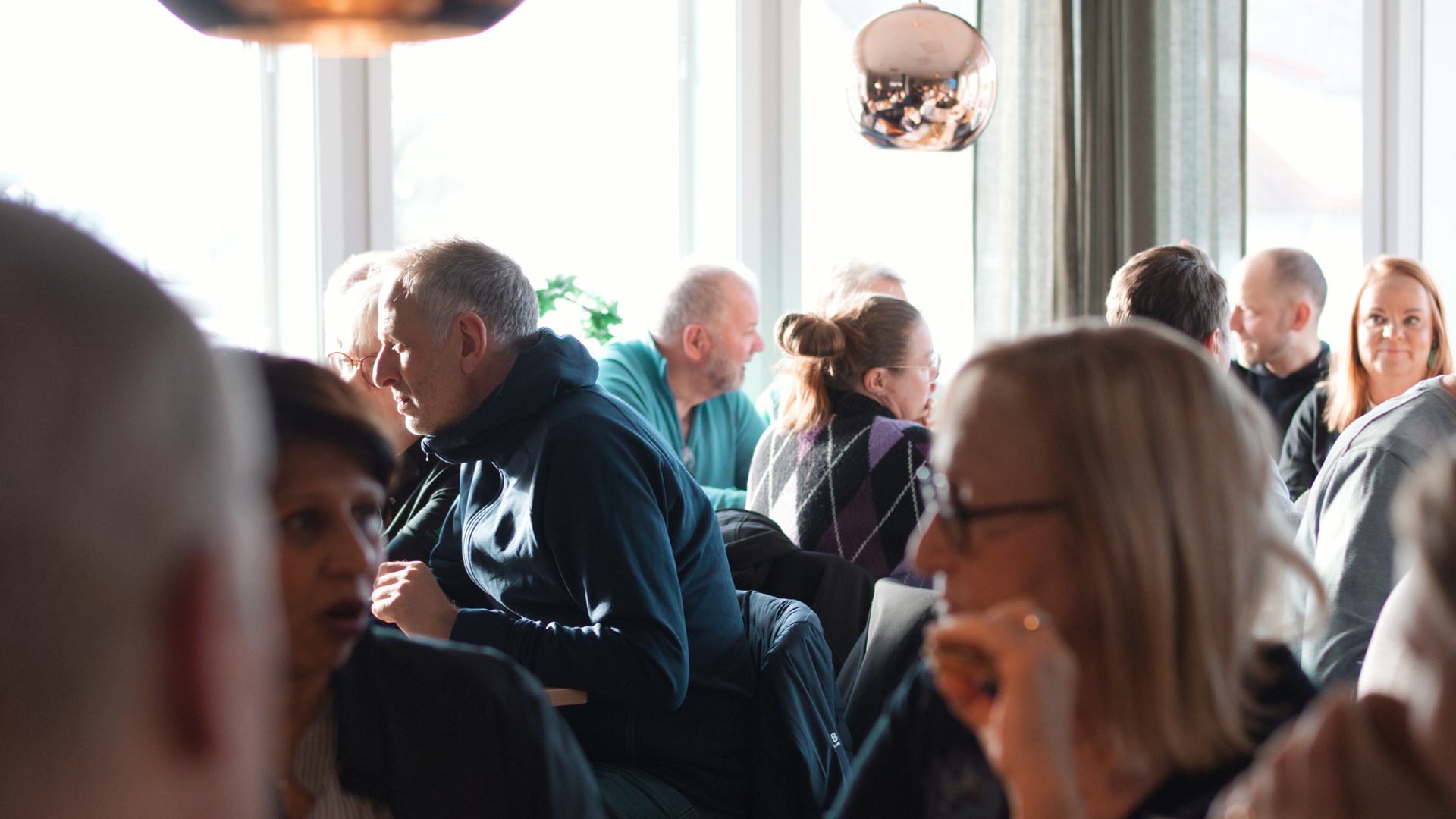 En grupp människor som sitter runt ett bord och fikar