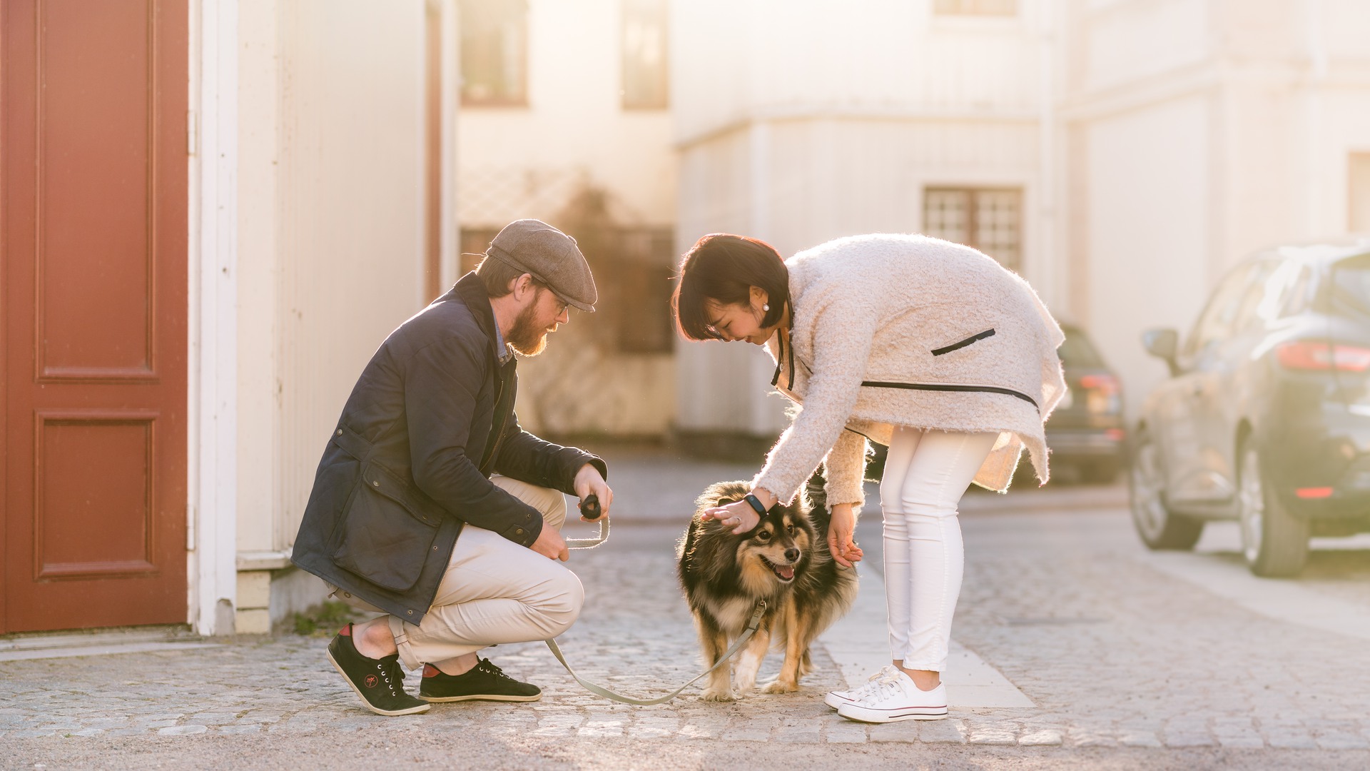 Två personer och en hund på en innergård i Hjo.