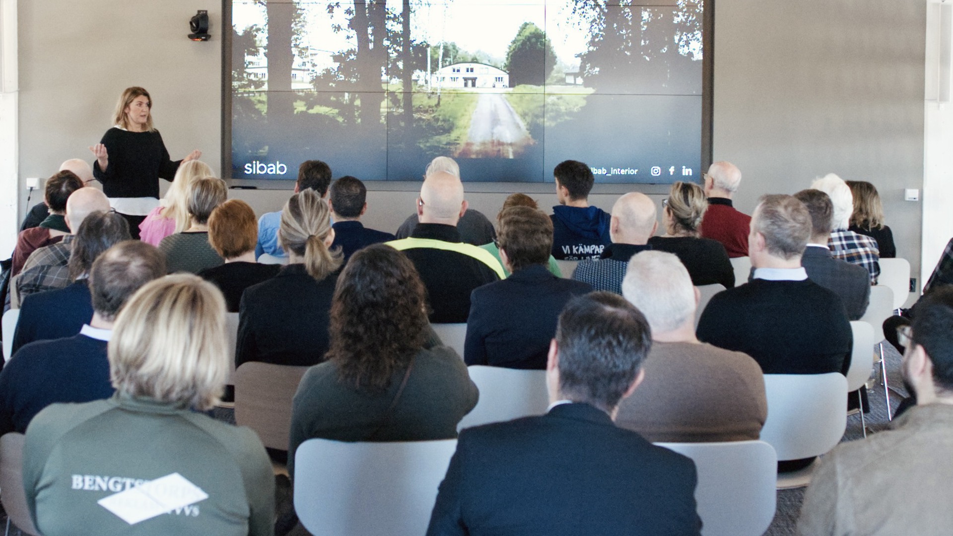 En grupp människor som sitter i stolar och tittar på en presentation