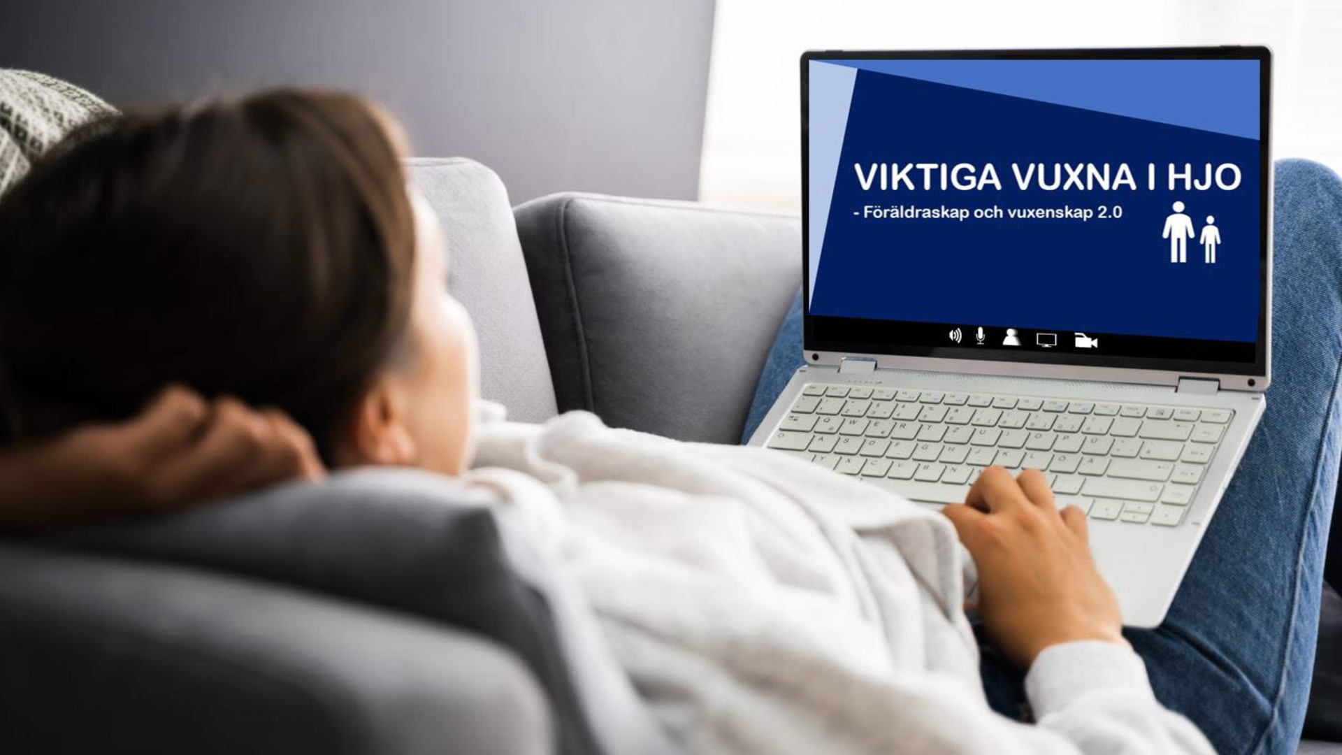 En person som ligger i en soffa och tittar på en dator med texten "Viktiga vuxna i Hjo".