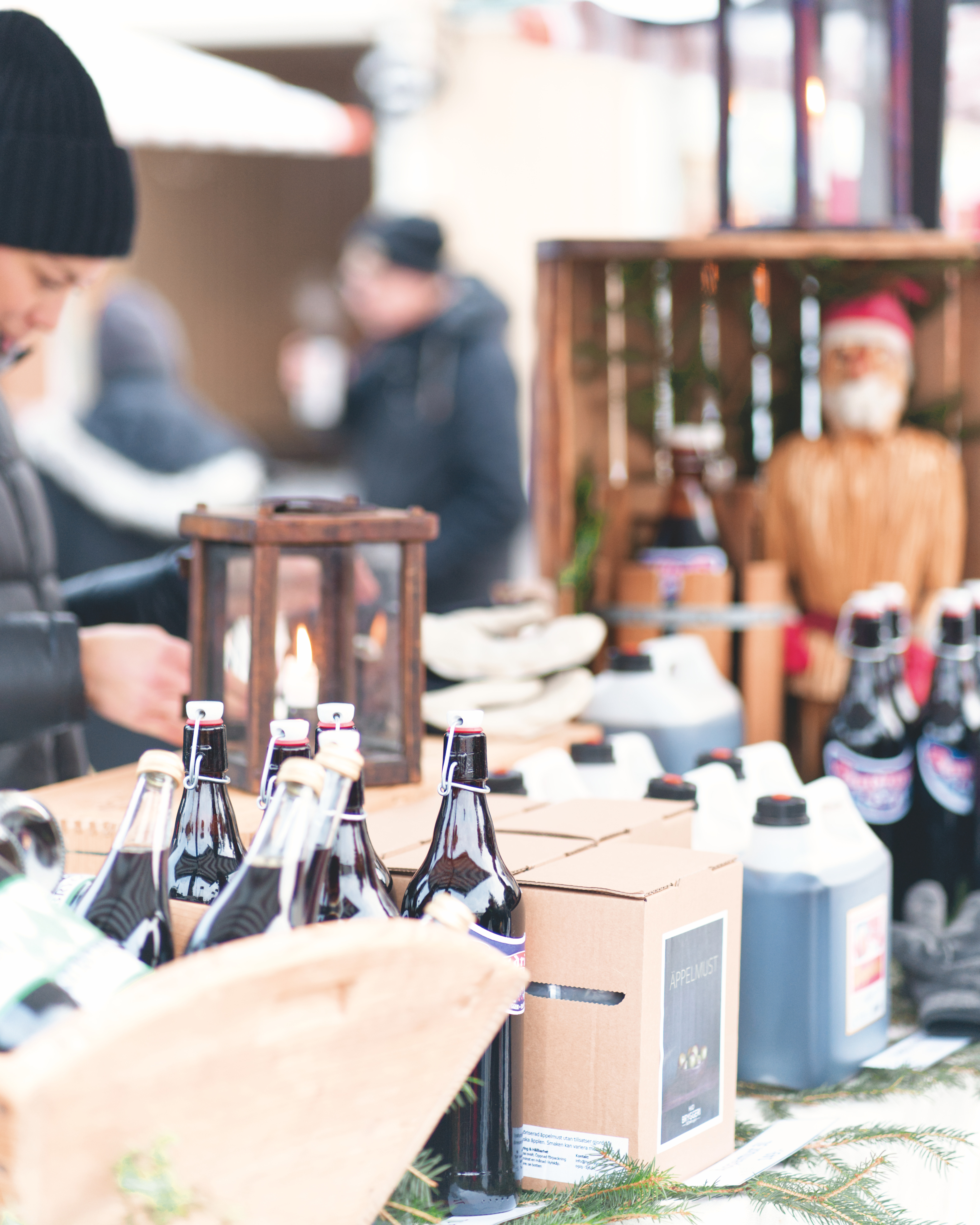 En man som står bredvid ett bord fyllt med flaskor