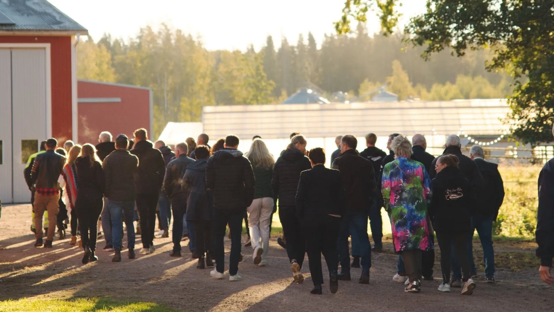 En grupp människor som går längs en grusväg.