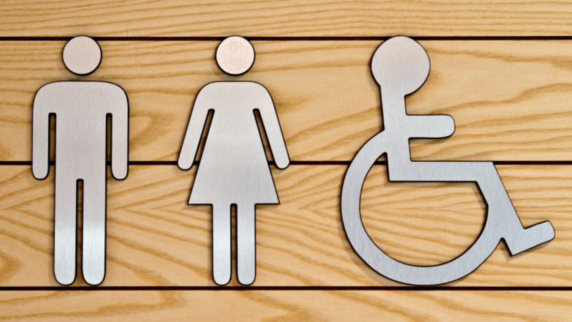 Symboler utanför en toalett: man, kvinna och handikapp.