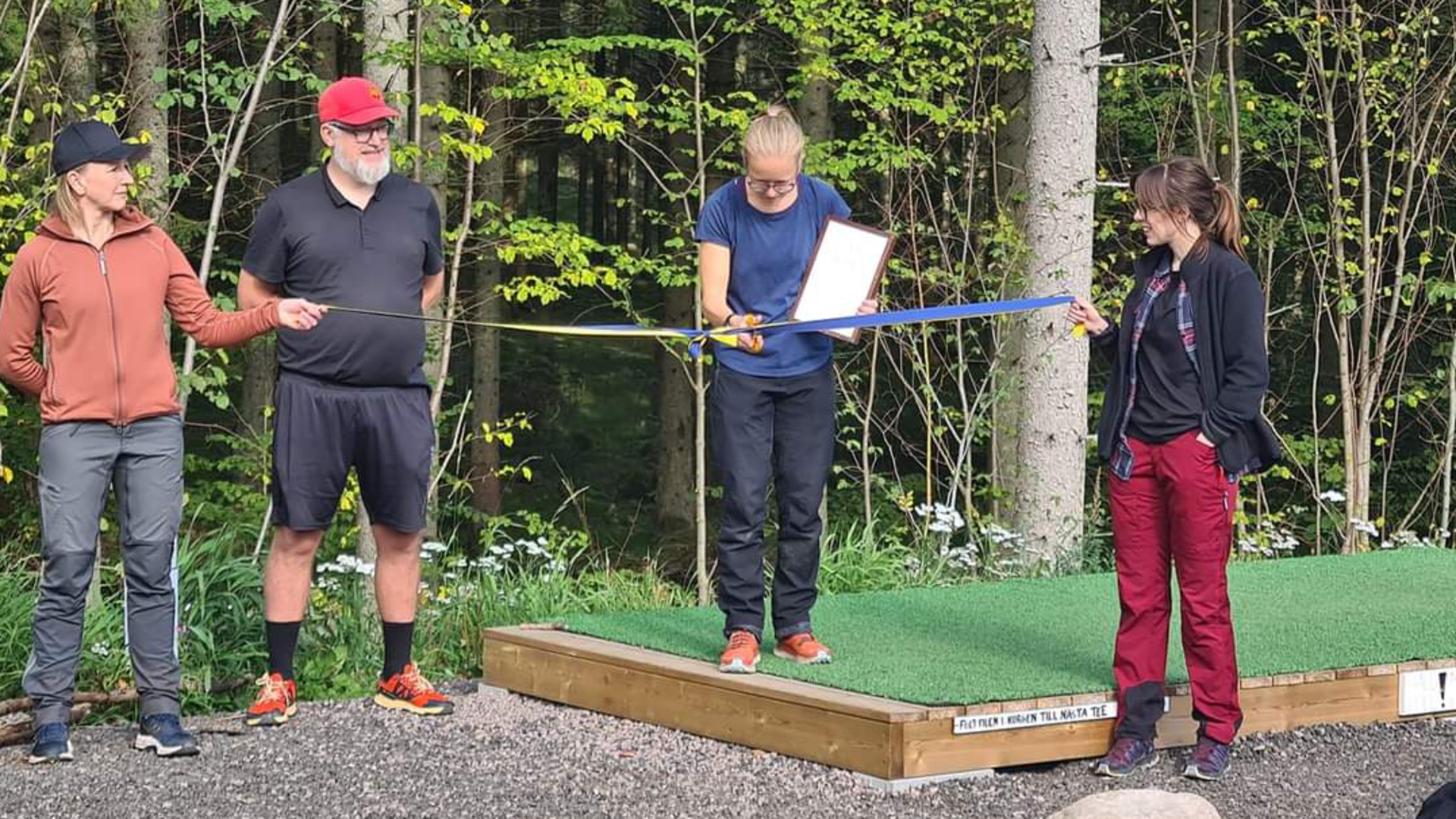 Fritidsutvecklare Hanna Nordlöf klipper bandet på invigningen av Hjo Discgolfpark.