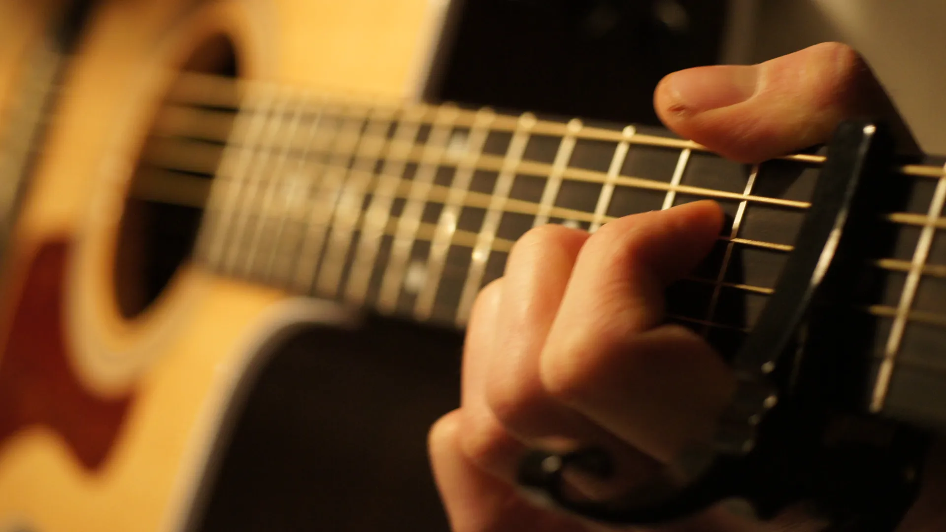 Närbild på en person som spelar gitarr