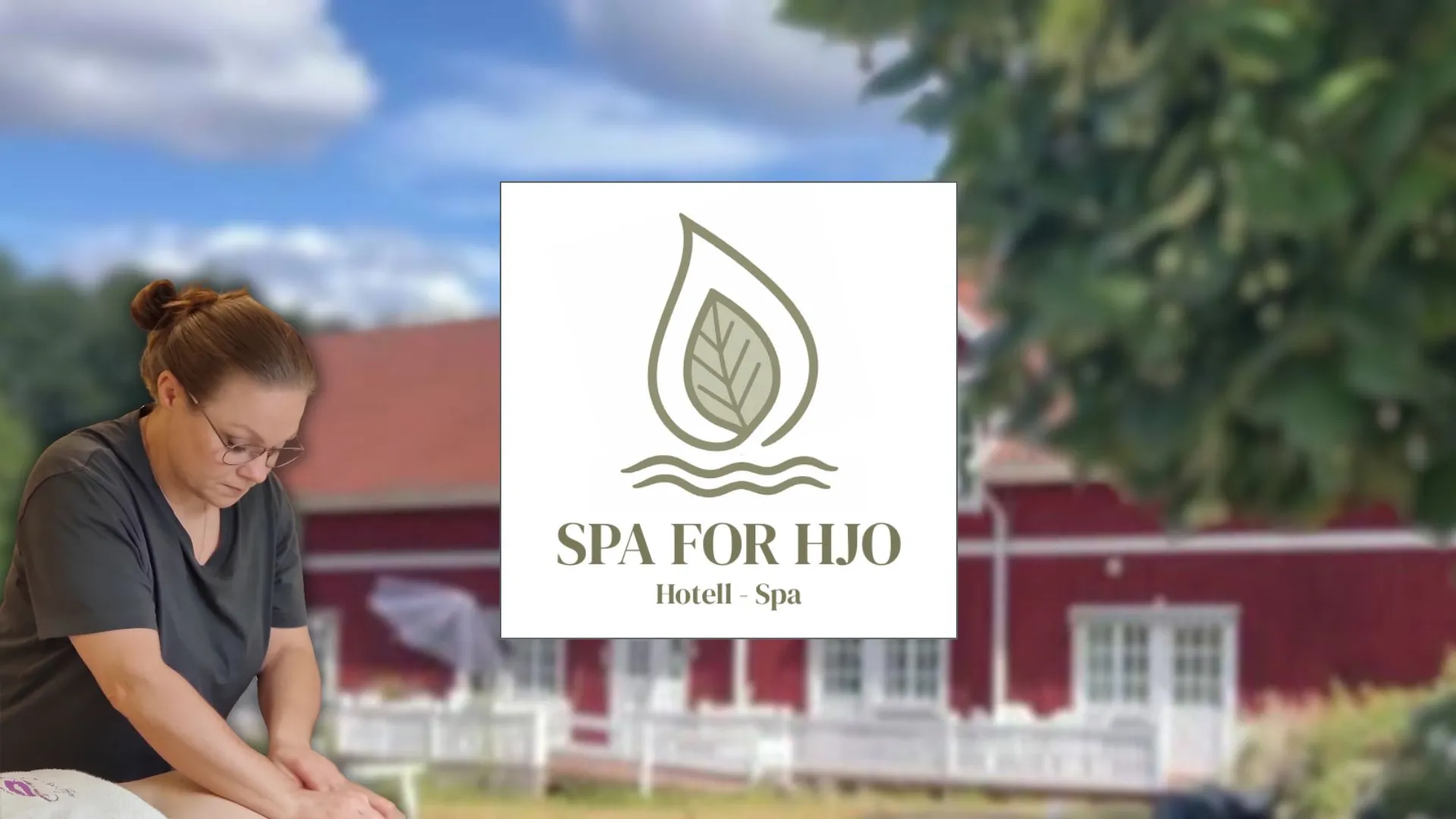 En kvinna utför massage framför en röd ladugård.