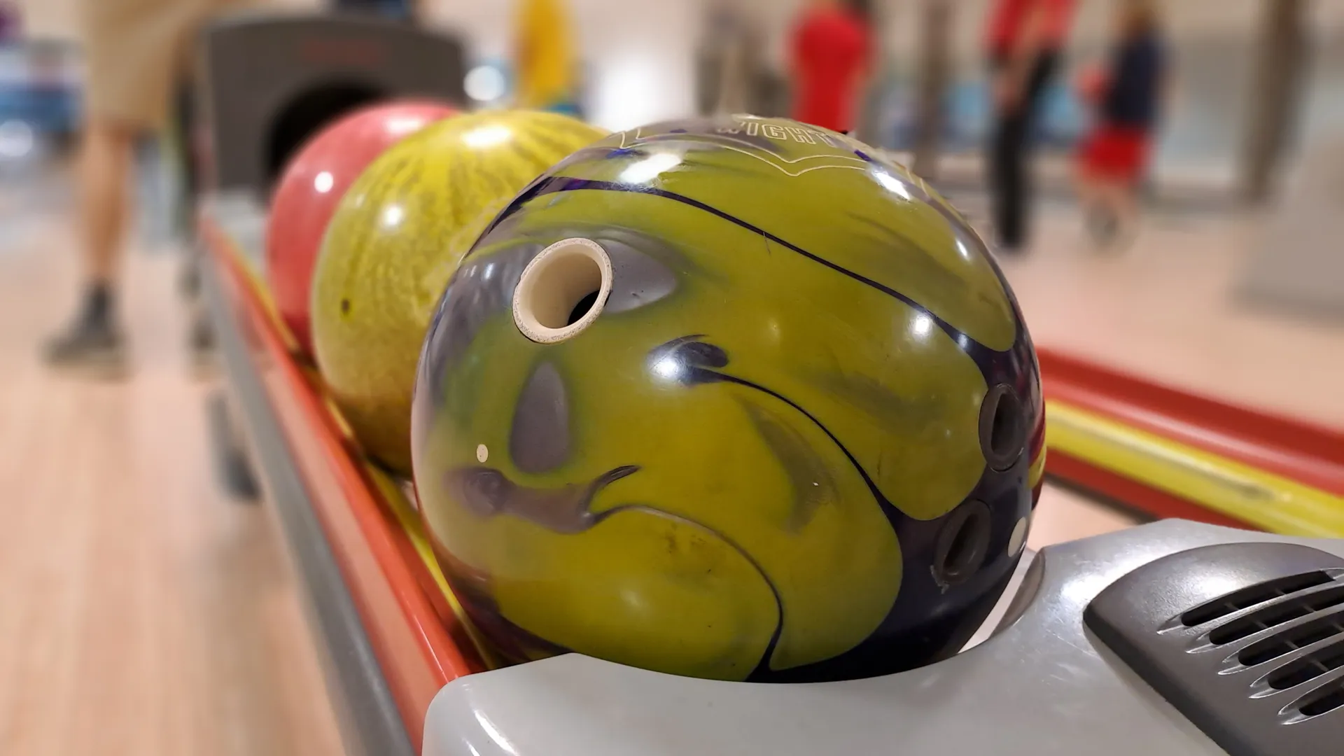 Bowlingklot i olika färger som ligger och väntar på att bli kastade.
