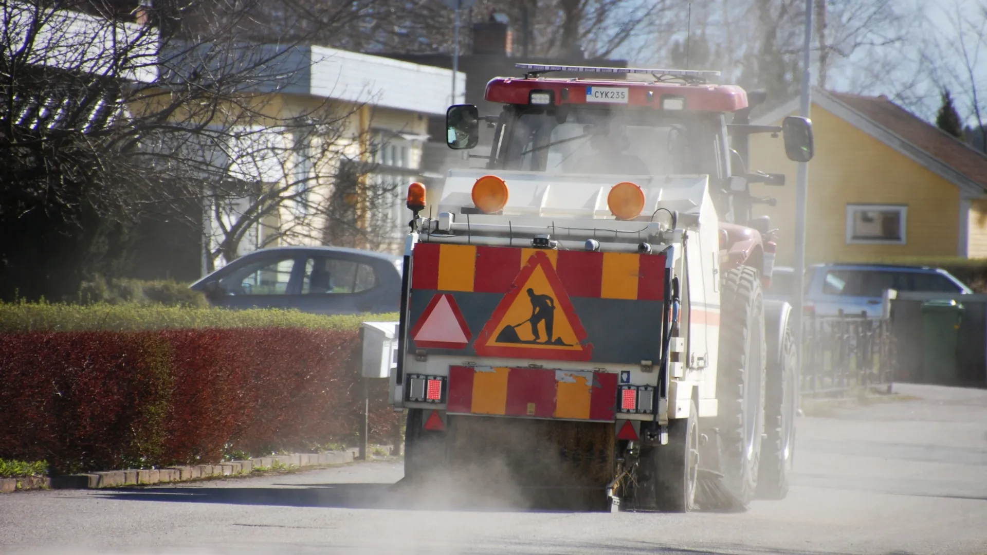 En maskin sopar gatorna i ett bostadsområde.