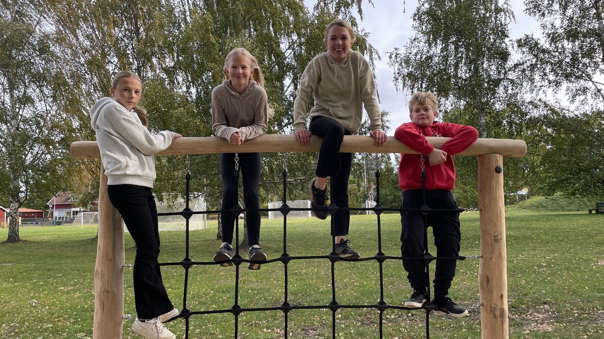 Fyra elever klättrar i ett nät på hinderbanan.