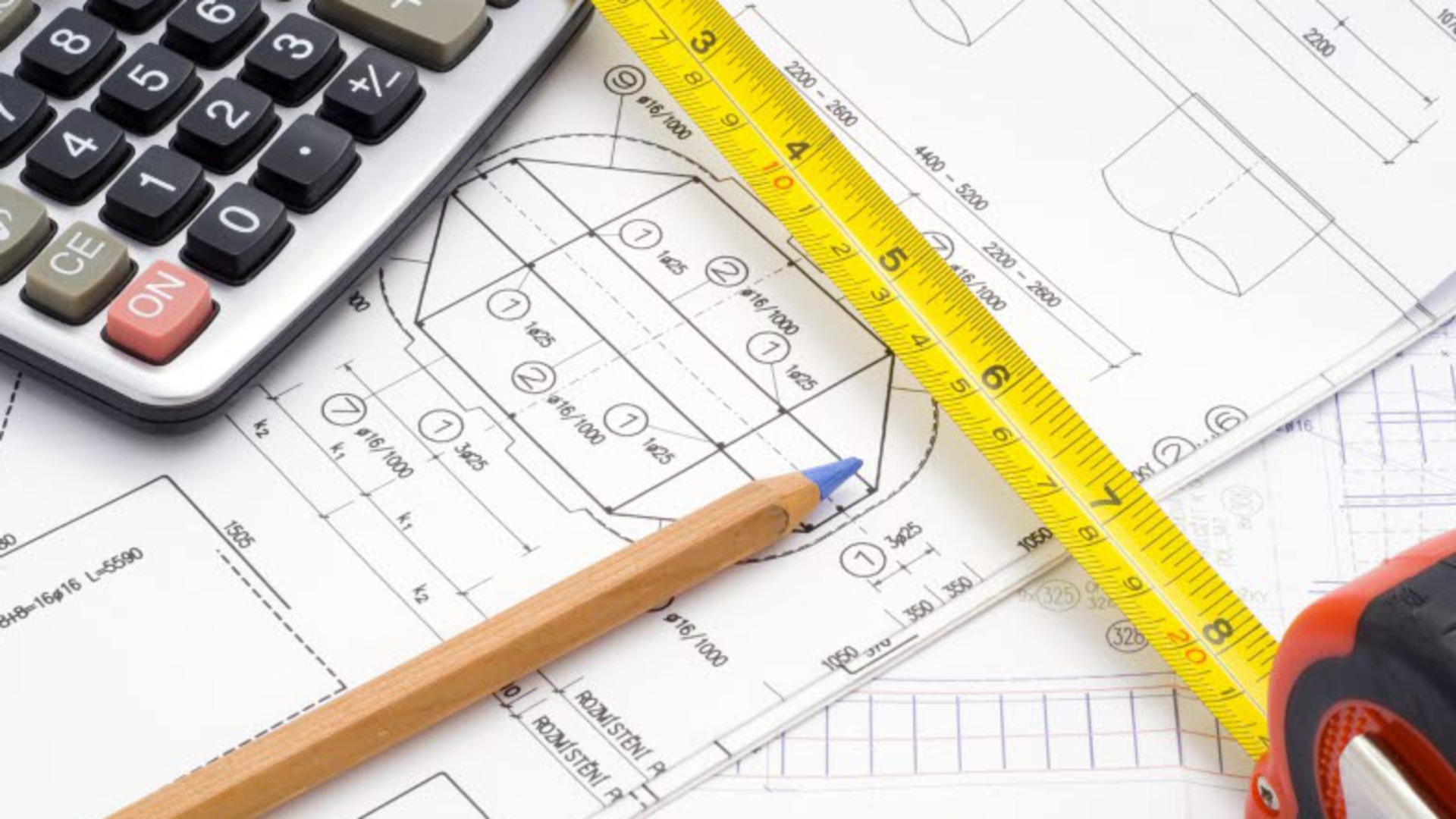 Närbild på delar av en ritning samt en penna, en linjal och en miniräknare.