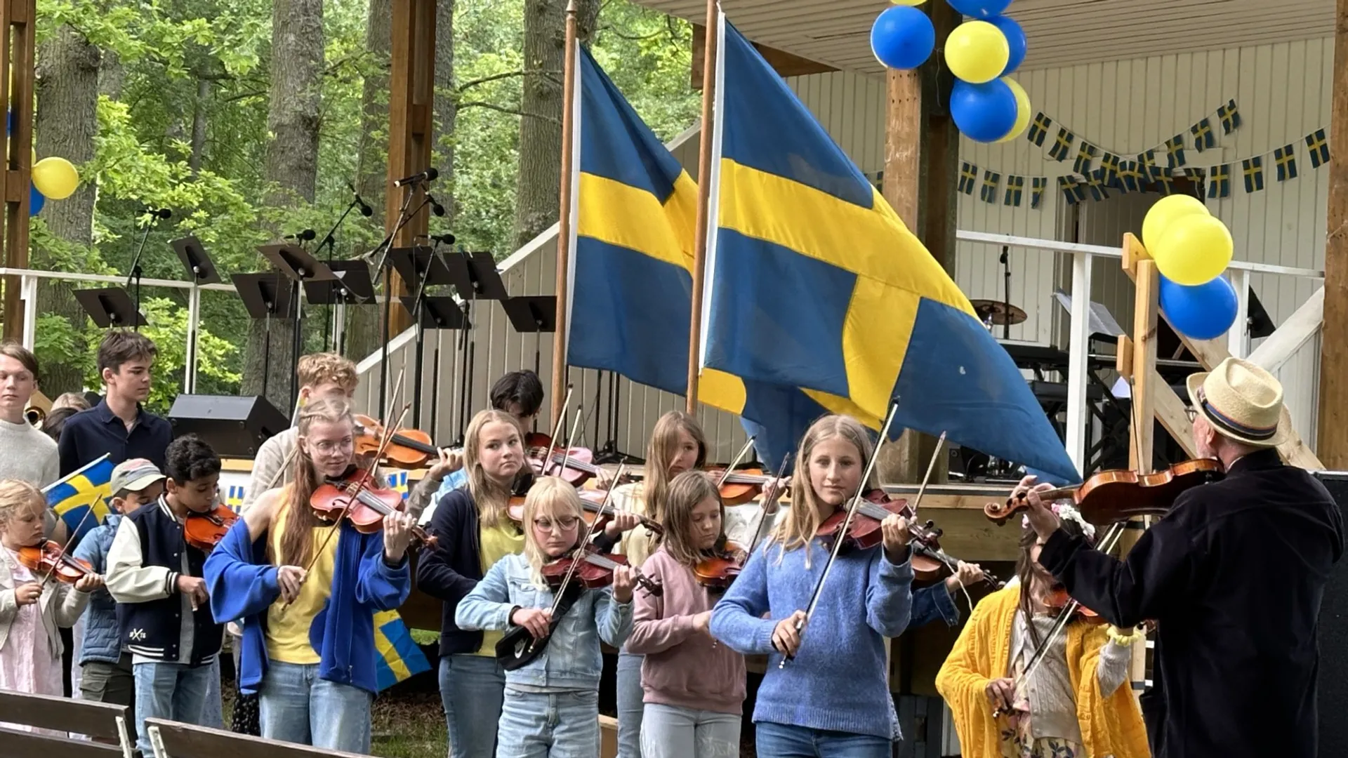 Elever från kulturskolan spelar framför scenen i stadsparken.