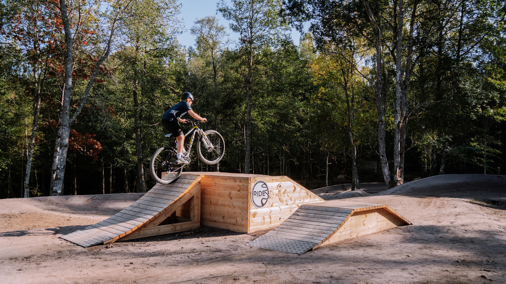 Ung cyklist på väg över ett cykelhinder av trä, vid nya Högaliden MTB Arena