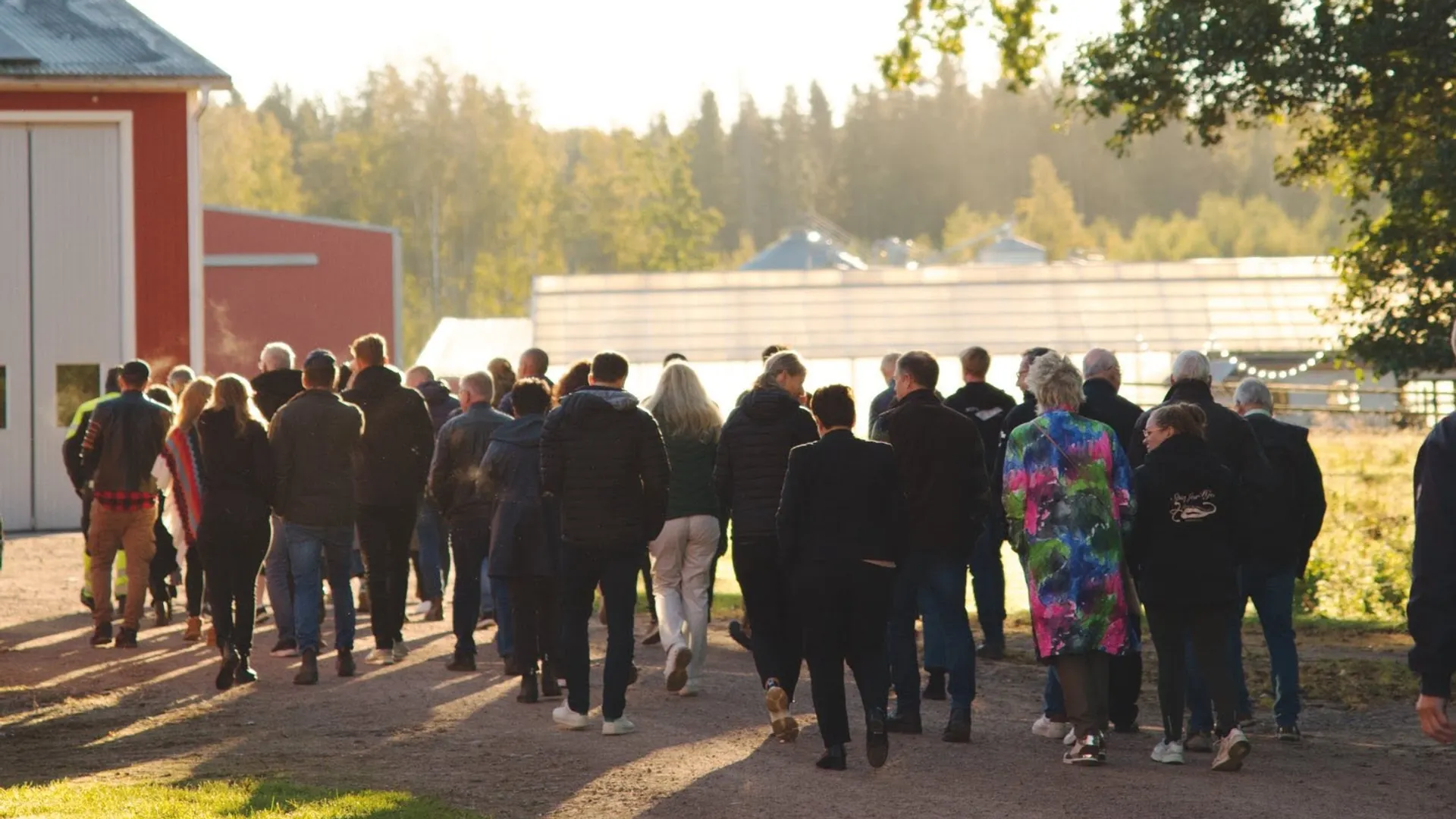 En grupp människor som går längs en grusväg.