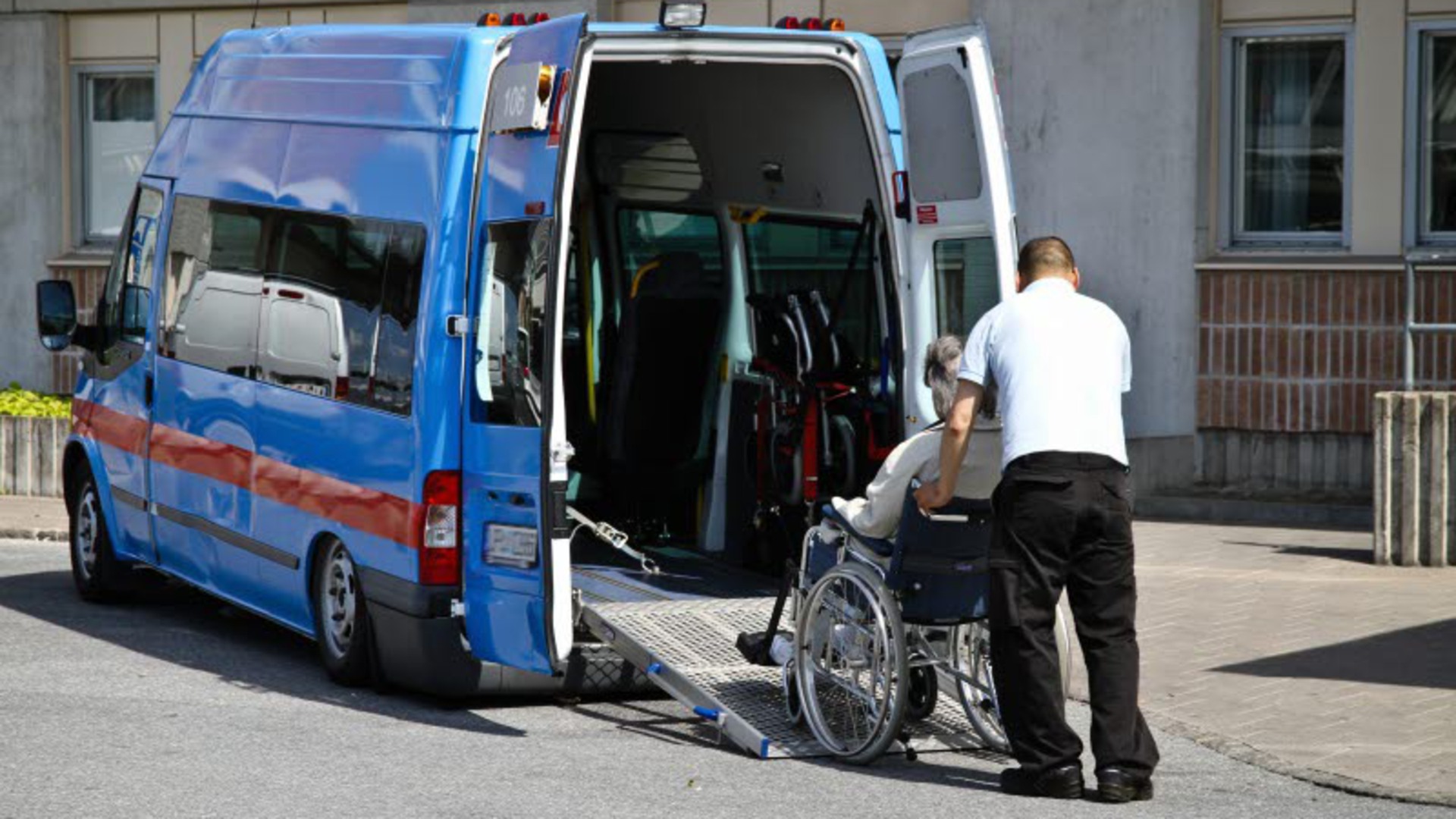 En person i rullstol rullas in i en färdtjänstbuss.