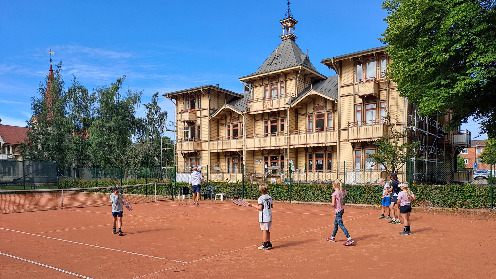 Några barn som spelar tennis i Hjo stadspark