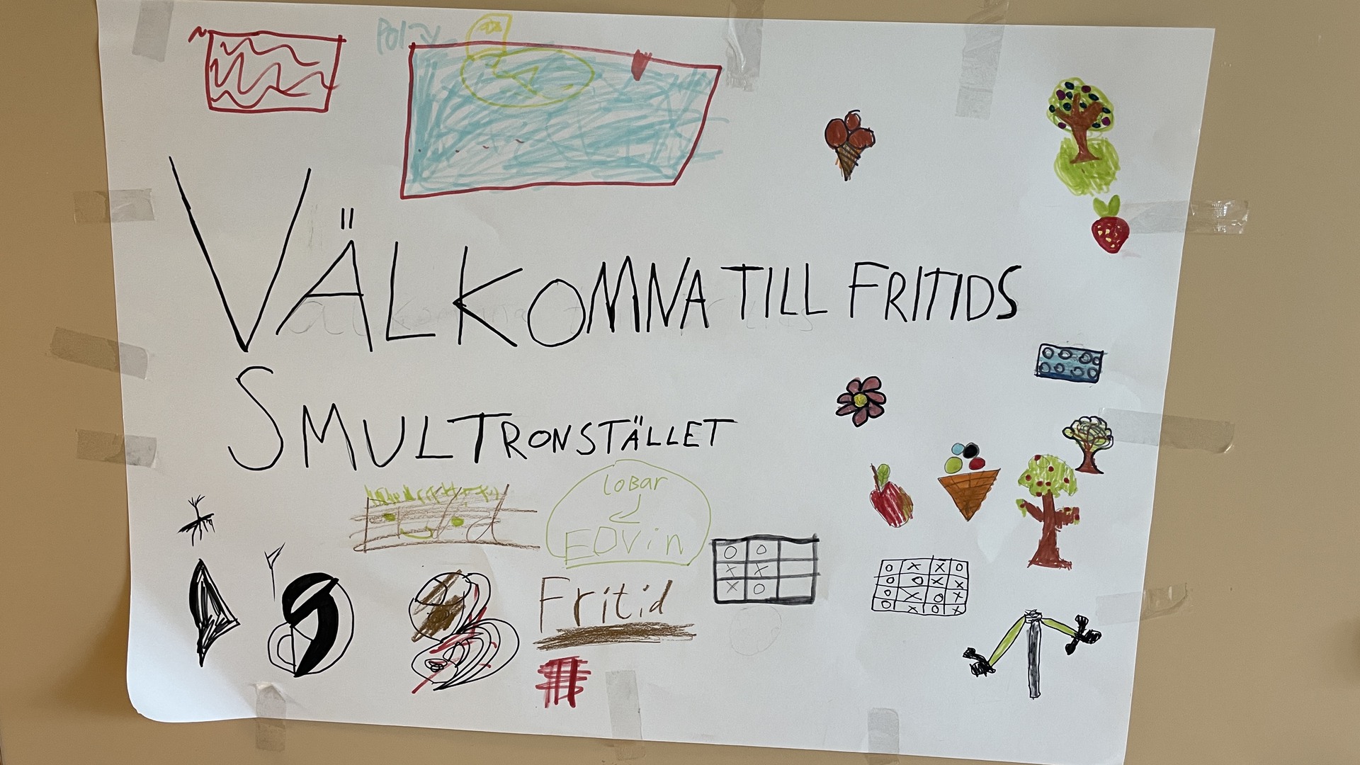 Skylten på dörren till Smultronstället, fritidshemmet på Fågelås skola. Skylten är en teckning med många små motiv.