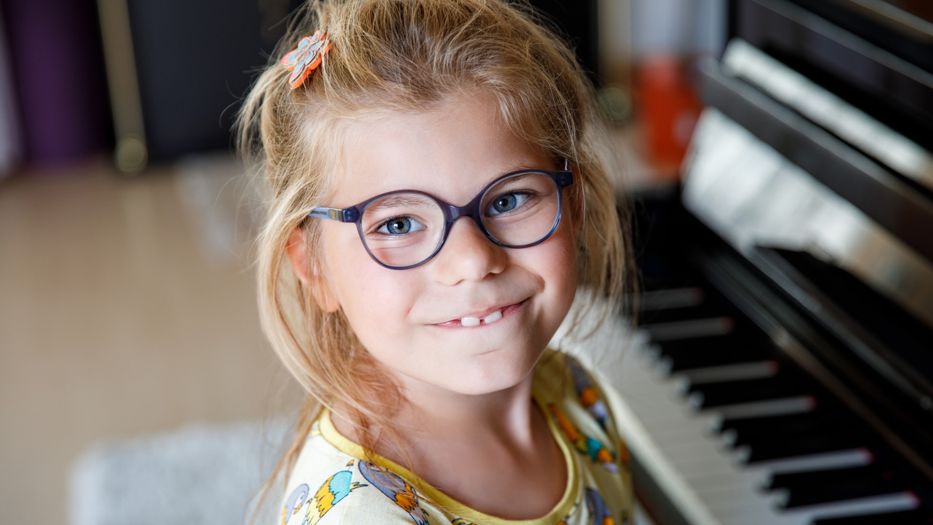 Flicka sitter vid ett piano.