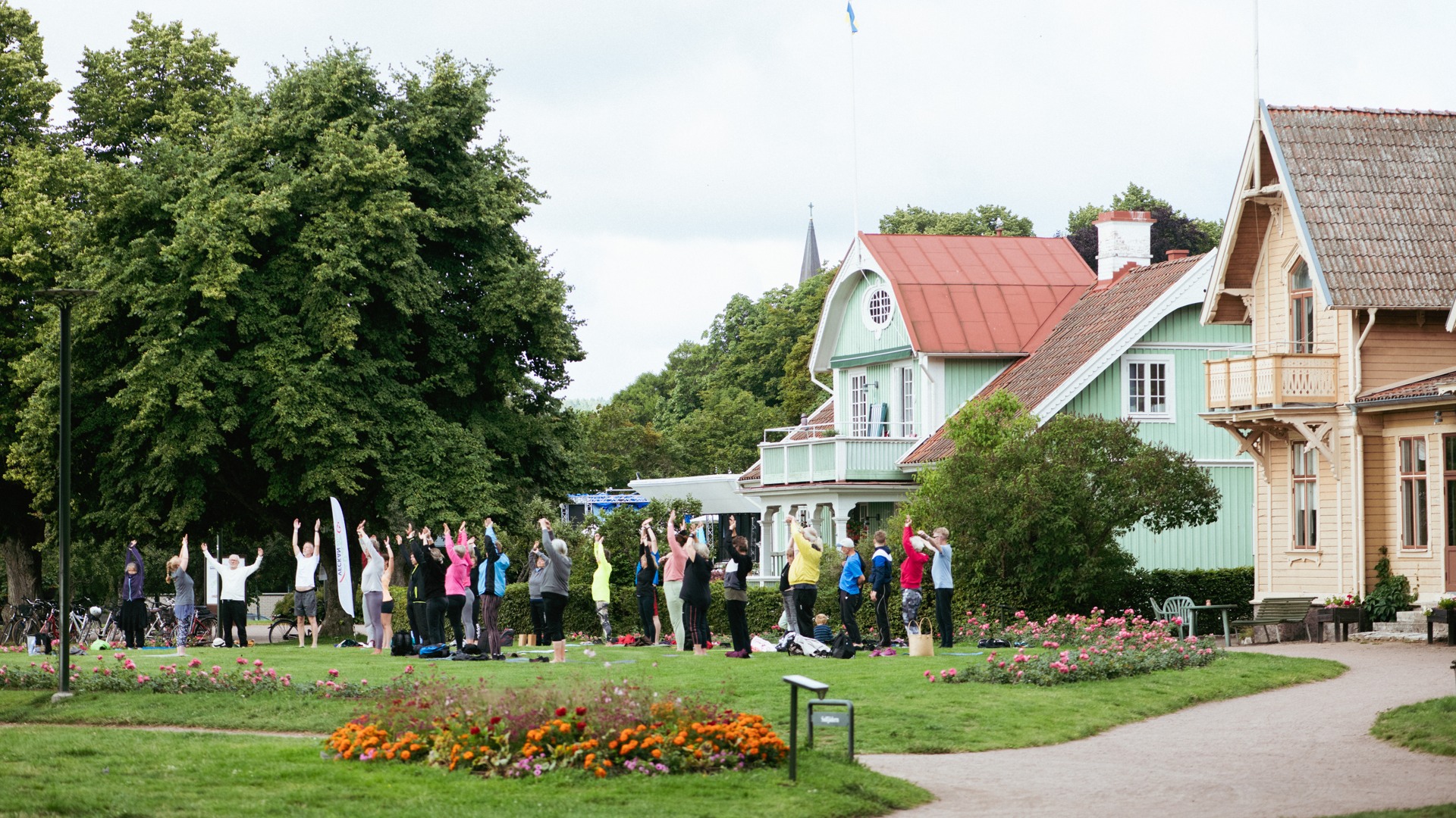 Människor yogar i stadsparken.