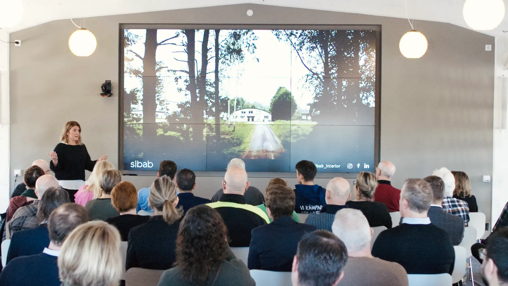 En grupp människor som sitter i stolar och tittar på en presentation