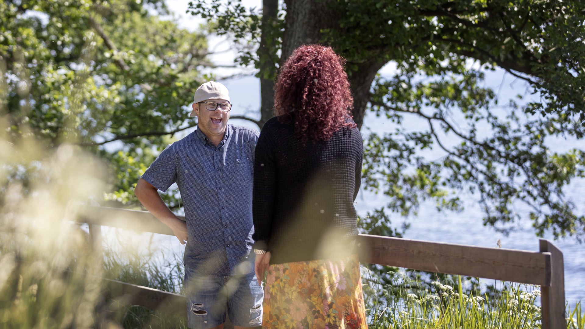 Två personer samtalar vid vattnet i stadsparken.