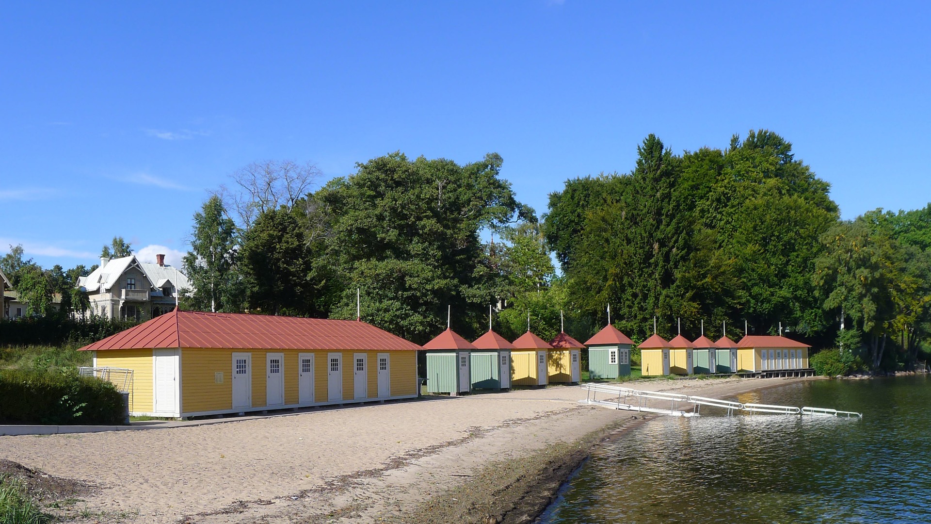 Färgglada badhytter och sandstrand i hamnen i Hjo.